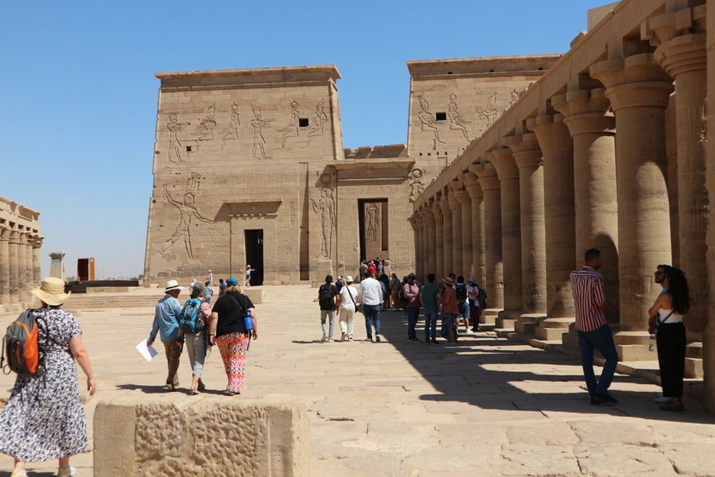 Groepsrondreis Egypte: reizigers bij de tempel van Philae met zuilengang en reliëfs.