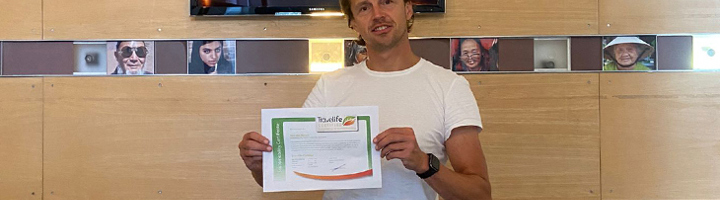 Medewerker van Sawadee toont Travelife-certificaat als bewijs van hercertificering.