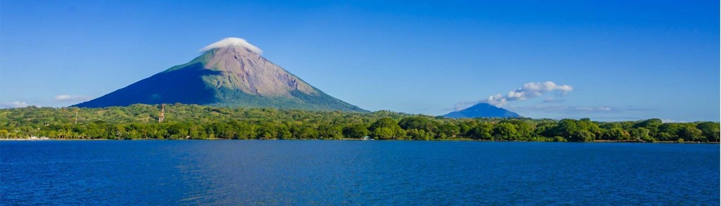 Vulkaan Concepción op Ometepe in het Meer van Nicaragua, met groene oevers en helderblauwe lucht.