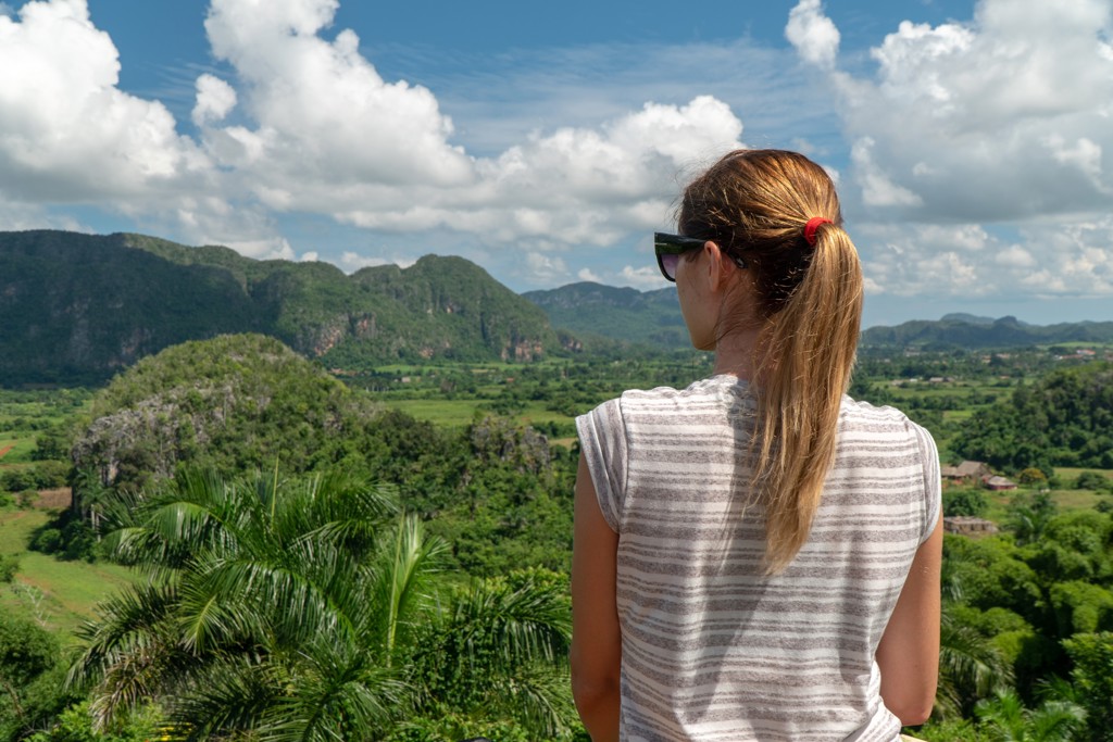 Reiziger kijkt uit over de groene Viñales-vallei in Cuba tijdens een familiereis.