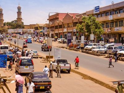Drukke straat in Lusaka, Zambia, met verkeer, voetgangers en winkels langs de weg.
