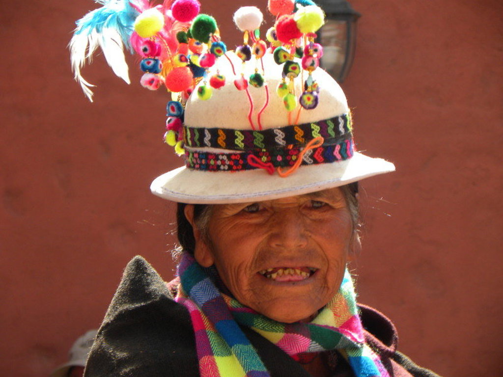 Portret van vrouw met kleurrijke traditionele hoed en sjaal tijdens groepsrondreis Bolivia en Chili.
