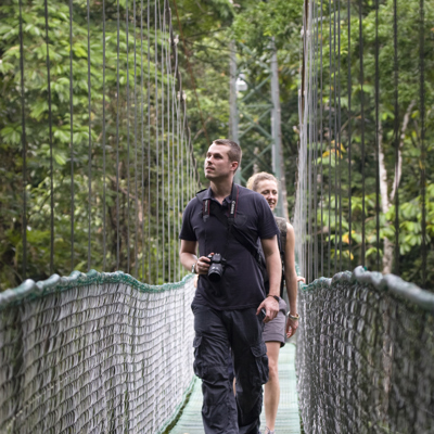 Reizigers wandelen over een hangbrug in het regenwoud tijdens de groepsrondreis Trans-Midden-Amerika.