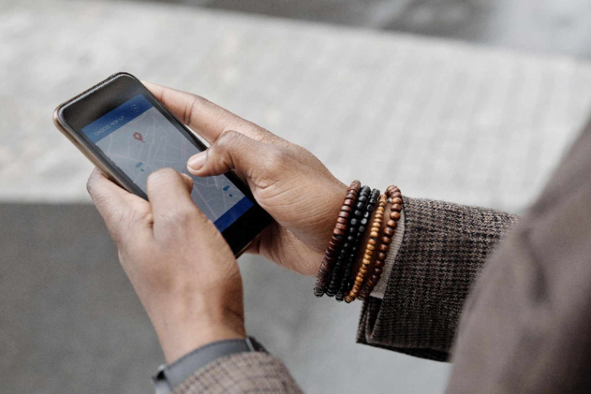 Handen gebruiken een smartphone met kaartapp voor navigatie onderweg.