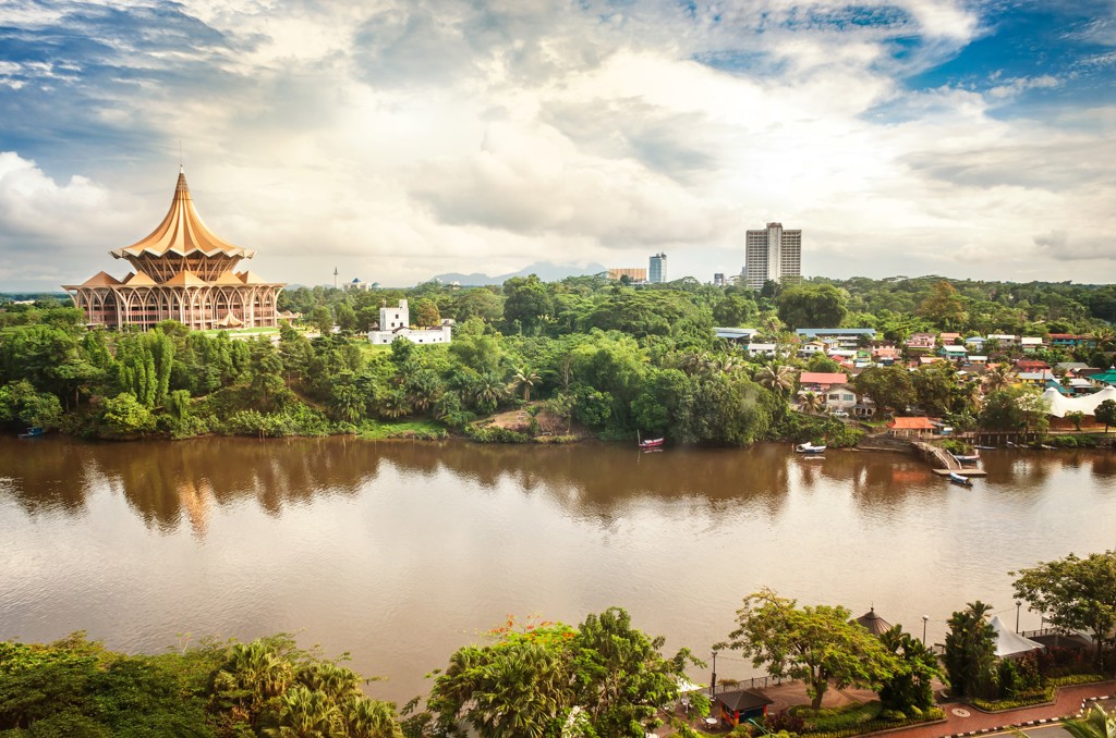 Rivierlandschap in Kuching, Maleisisch Borneo, met het Sarawak State Legislative Assembly-gebouw en de stad op de oever.