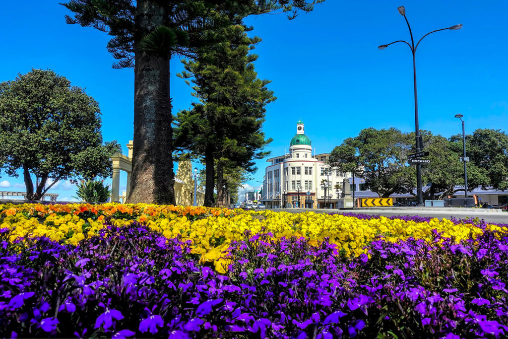Bloemenperk met paarse en gele bloemen bij Art Deco-gebouw in Napier, Nieuw-Zeeland.