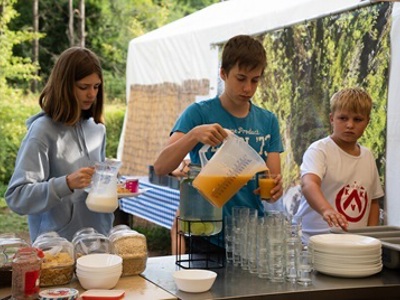 Kinderen schenken sap en melk in tijdens het ontbijt op de camping tijdens de familiereis Aragon - Rio Cinca, Spanje.