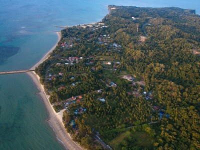 een kustdorp met strand en groen regenwoud op Maleisisch Borneo.