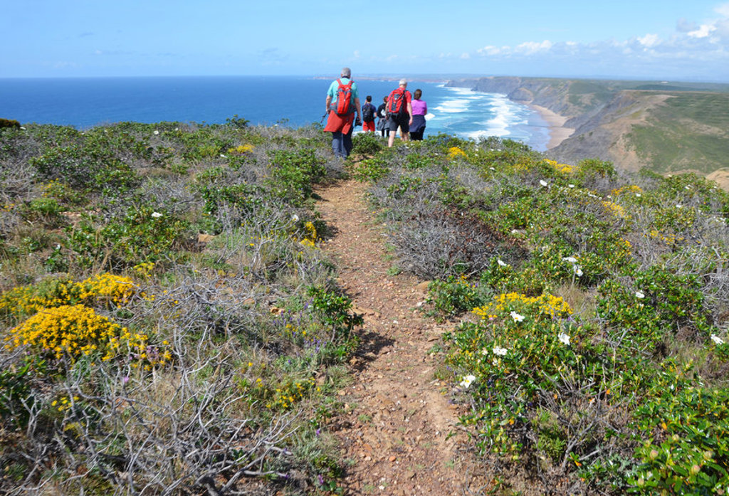 Wandelaars op kustpad langs de Costa Vicentina met uitzicht op kliffen en oceaan in Alentejo en Algarve, Portugal.