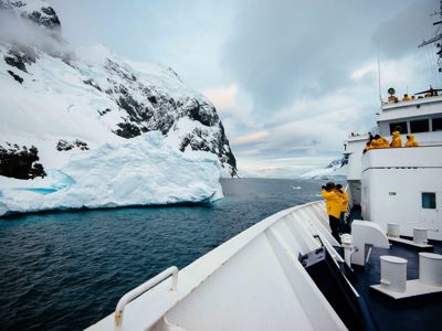 Expeditiecruise langs ijsbergen en gletsjers in Spitsbergen, met reizigers op het dek.