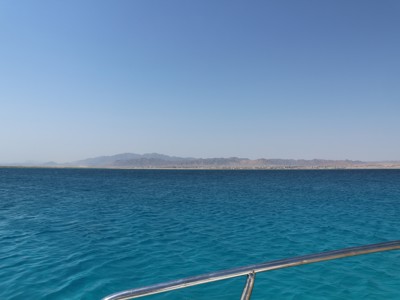 Uitzicht vanaf een boot op de Rode Zee met turquoise water en bergen aan de kust in Egypte.