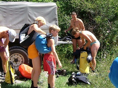 Gezin trekt wetsuits en zwemvesten aan voor canyoning in de Mercantour & Vésubie-route.