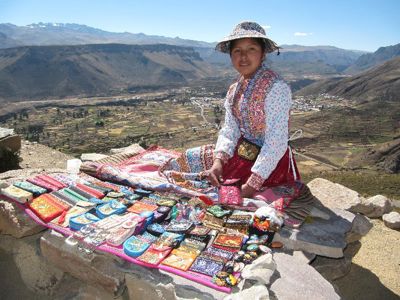 Marktvrouw met kleurrijke handgemaakte textiel en souvenirs in de Colca Canyon, Peru.