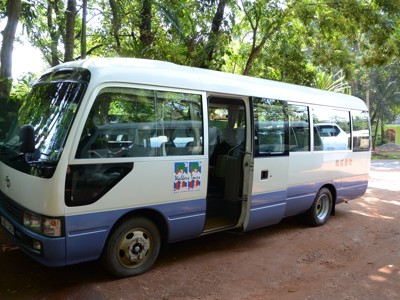 Minibus voor groepsreis op Route Sri Lanka, geparkeerd langs een weg in het groen.