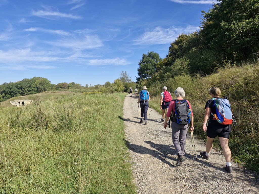 Wandelaars op de Dutch Mountain Trail in Zuid-Limburg, Nederland, over een grindpad door heuvelachtig landschap.