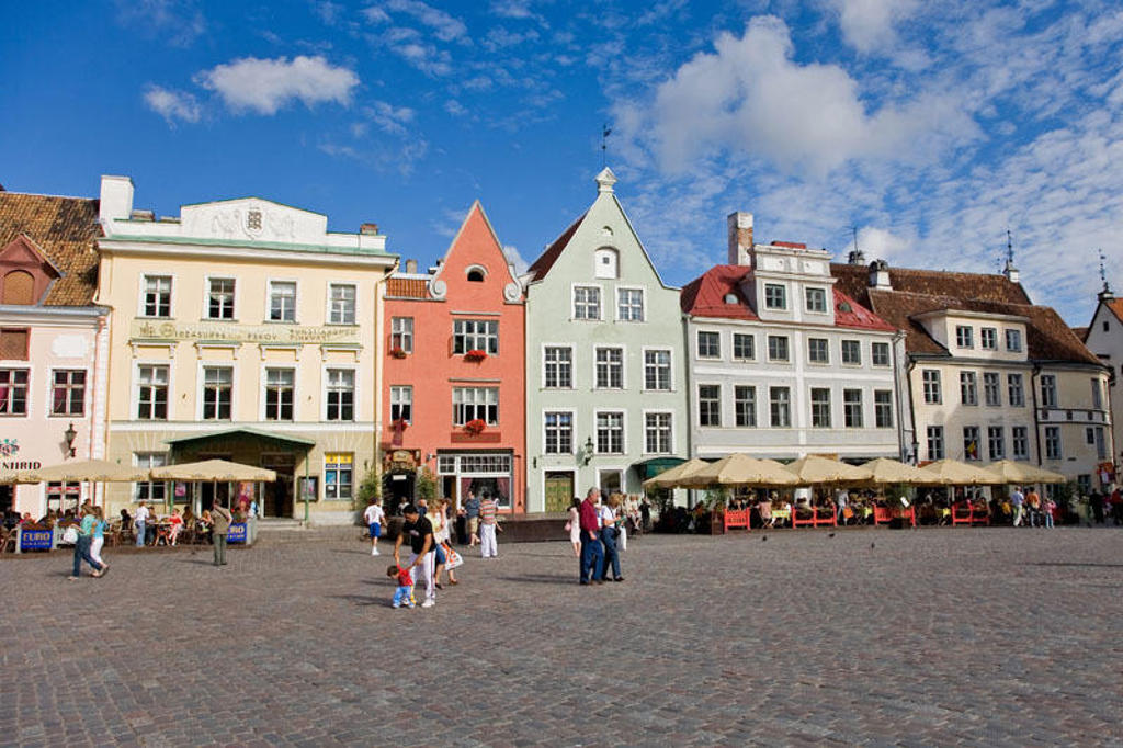 Pastelkleurige gevels en terrasjes op het Raadhuisplein in Tallinn, tijdens familiereis Polen en Baltische Staten.