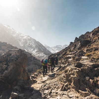 Groep wandelaars op bergpad in het Atlasgebergte tijdens de beklimming van Mount Toubkal in Marokko.