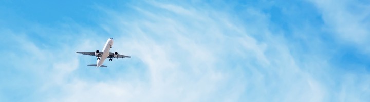 Vliegtuig stijgt op in blauwe lucht, passend bij tips voor comfort en vermaak tijdens de vlucht.