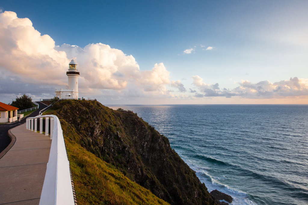 Vuurtoren op een klif aan de kust van Australië met uitzicht op de oceaan bij zonsondergang.