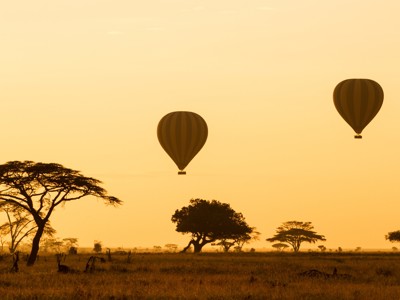 Luchtballonnen bij zonsopgang boven de savanne in Kenia en Tanzania.