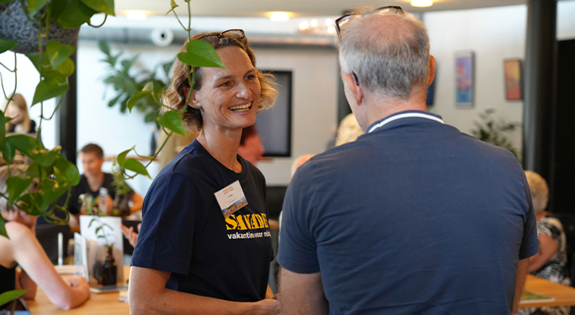 Infodag Eindhoven Reisadviseur van Sawadee in gesprek met een klant tijdens een informatiebijeenkomst.