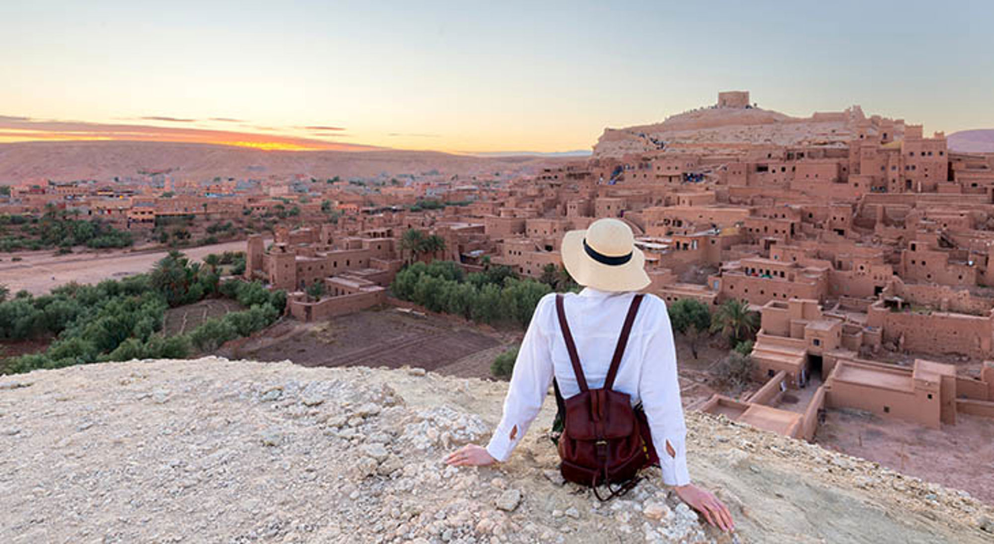 Ouarzazate Reiziger kijkt uit over de kasbah van Aït Ben Haddou bij zonsondergang in Marokko.