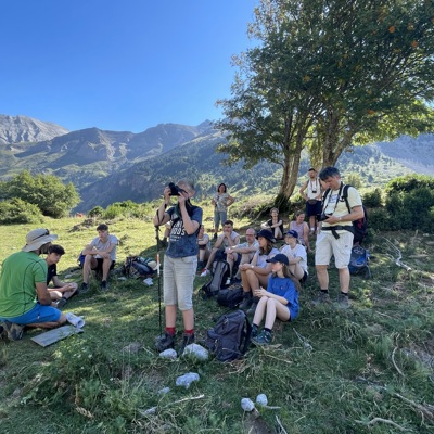 Gezin en gids pauzeren tijdens een bergwandeling in Kroatië en Montenegro, met uitzicht op groene bergtoppen.