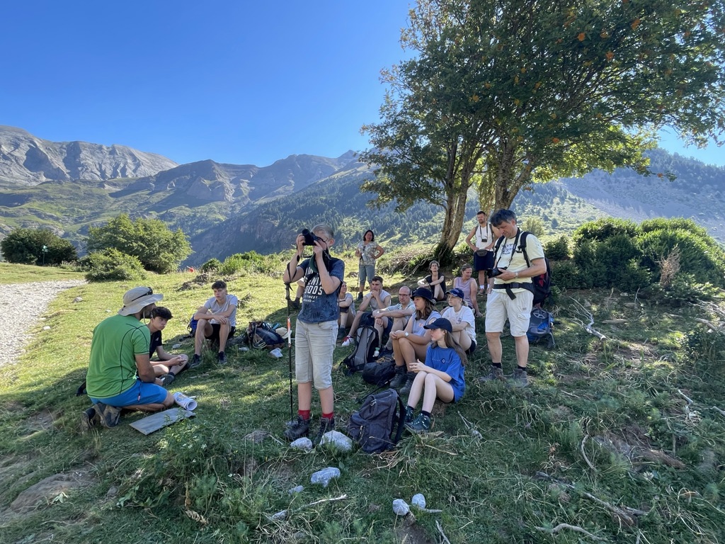 Gezin en gids pauzeren tijdens een bergwandeling in Kroatië en Montenegro, met uitzicht op groene bergtoppen.