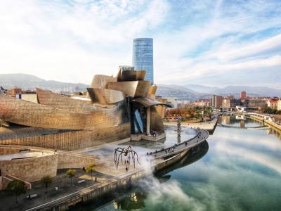 Guggenheim Museum in Bilbao aan de rivier, met de grote spinnenkunstwerk Maman op het plein.