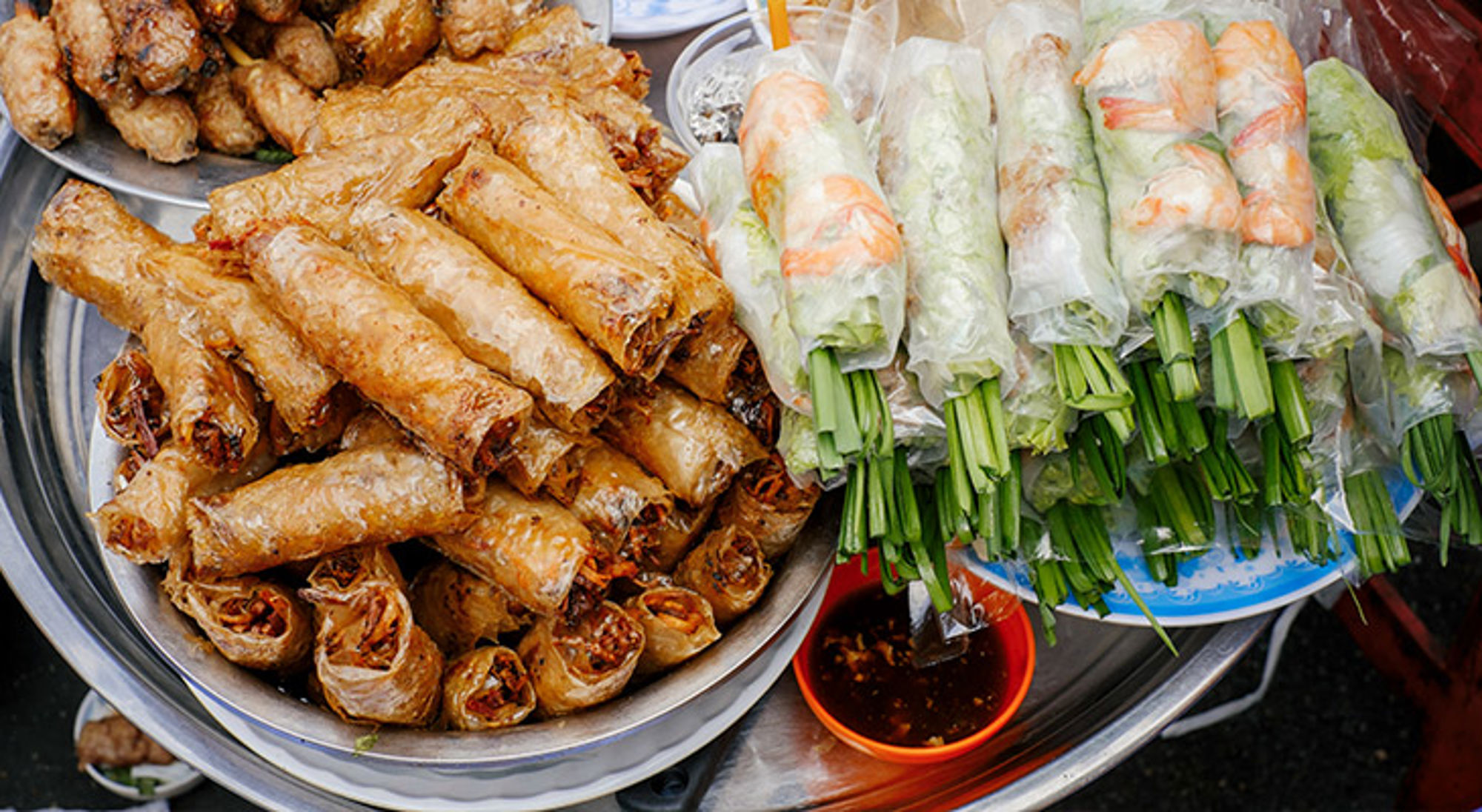 Vietnamese loempia’s en verse springrolls met garnalen en kruiden, geserveerd met dipsaus.