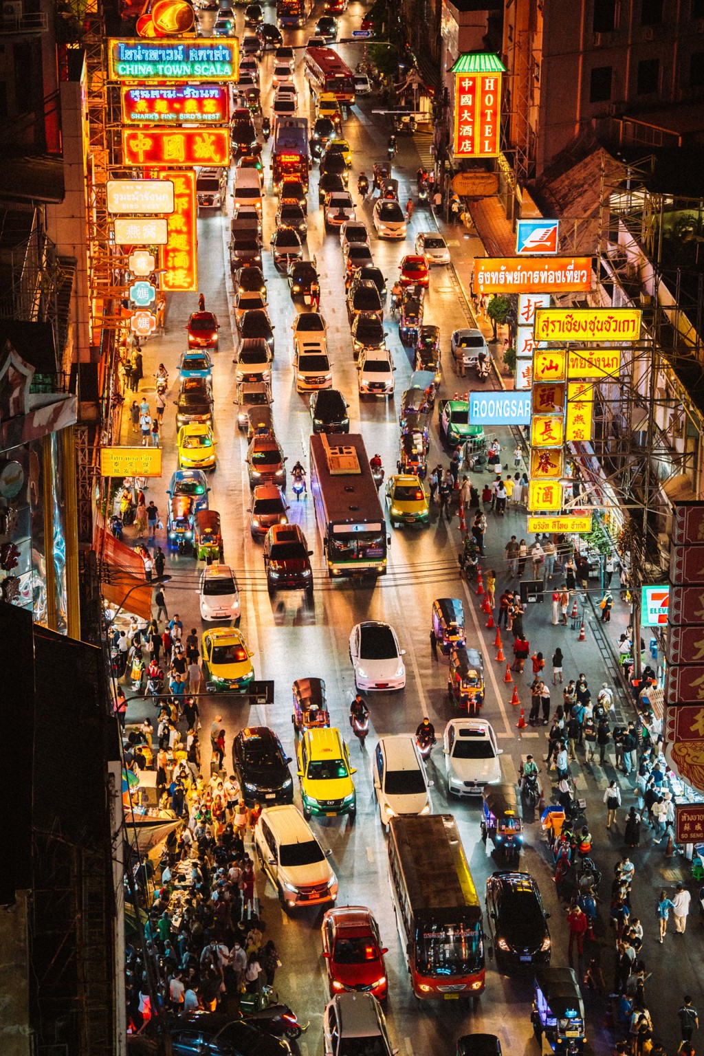 Drukke straat in Bangkok met neonreclames, verkeer en markten in de avond, tijdens groepsrondreis Thailand Hoogtepunten.
