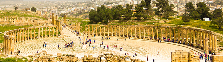Romeins amfitheater in Jerash met zuilengalerijen en bezoekers, met uitzicht op de stad in Jordanië.