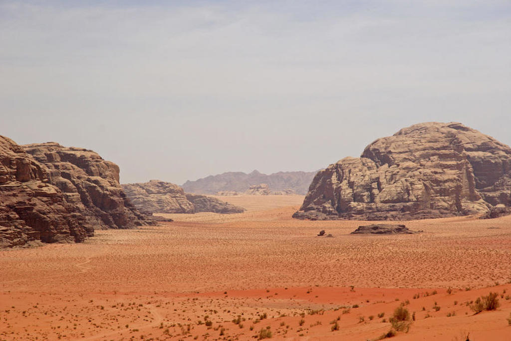 Rode zandduinen en rotsformaties in de woestijn van Wadi Rum, Jordanië.