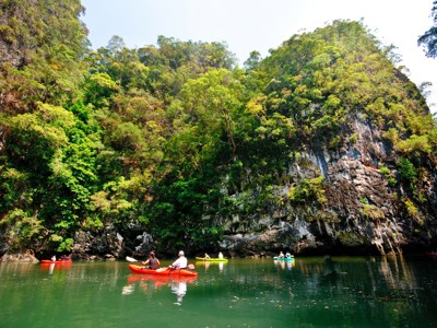 Kajakkers op een groene rivier langs kalkstenen kliffen in Zuid-Thailand tijdens de Route Zuid-Thailand.