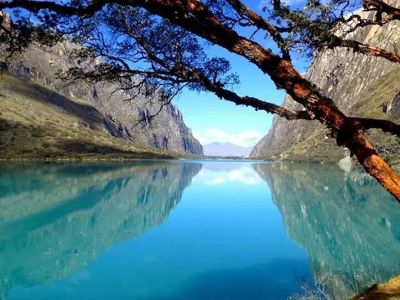 Turquoise bergmeer in de Cordillera Blanca, omringd door steile rotswanden en weerspiegeld in het water.