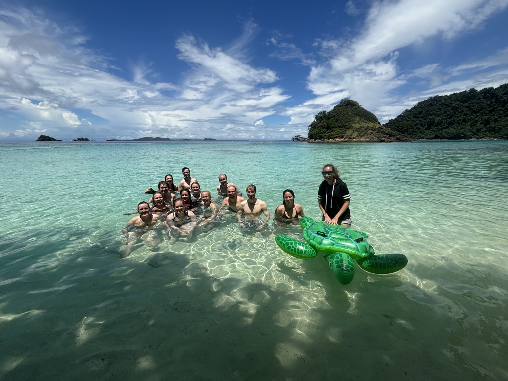 22-35ers groep zwemt in helderblauw water bij een tropisch eiland tijdens reis Thailand, Laos & Cambodja.
