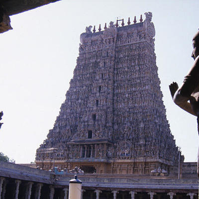 Hindoetempel met hoge gopuram, gezien vanaf een poort met beelden, tijdens groepsrondreis Zuid-India.