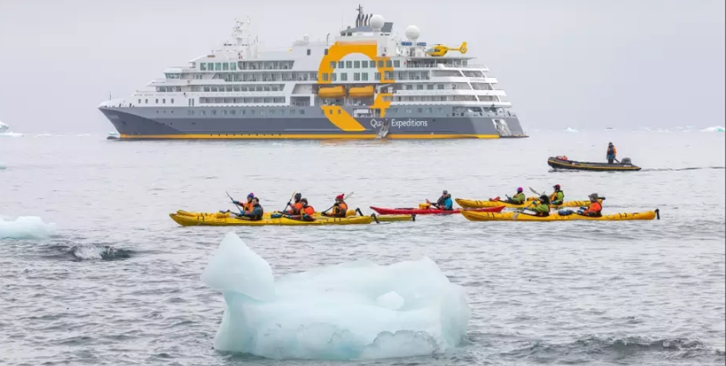 Kajakkers bij Snow Hill eiland in Antarctica, met expeditieschip op de achtergrond.