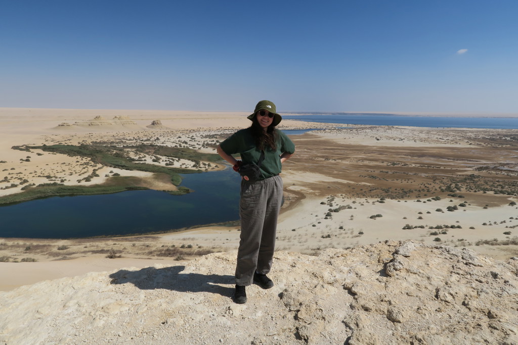 Reiziger kijkt uit over woestijnlandschap met blauw meer in Egypte tijdens een groepsrondreis.