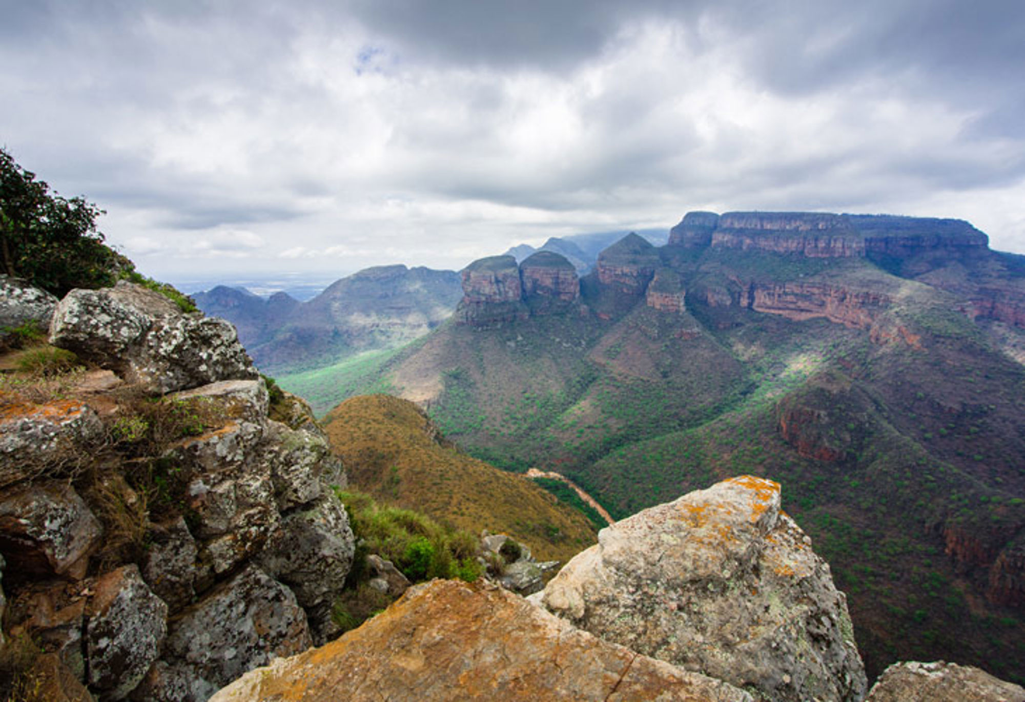 Uitzicht over de Three Rondavels in de Blyde River Canyon vanaf een rotsachtig uitkijkpunt.